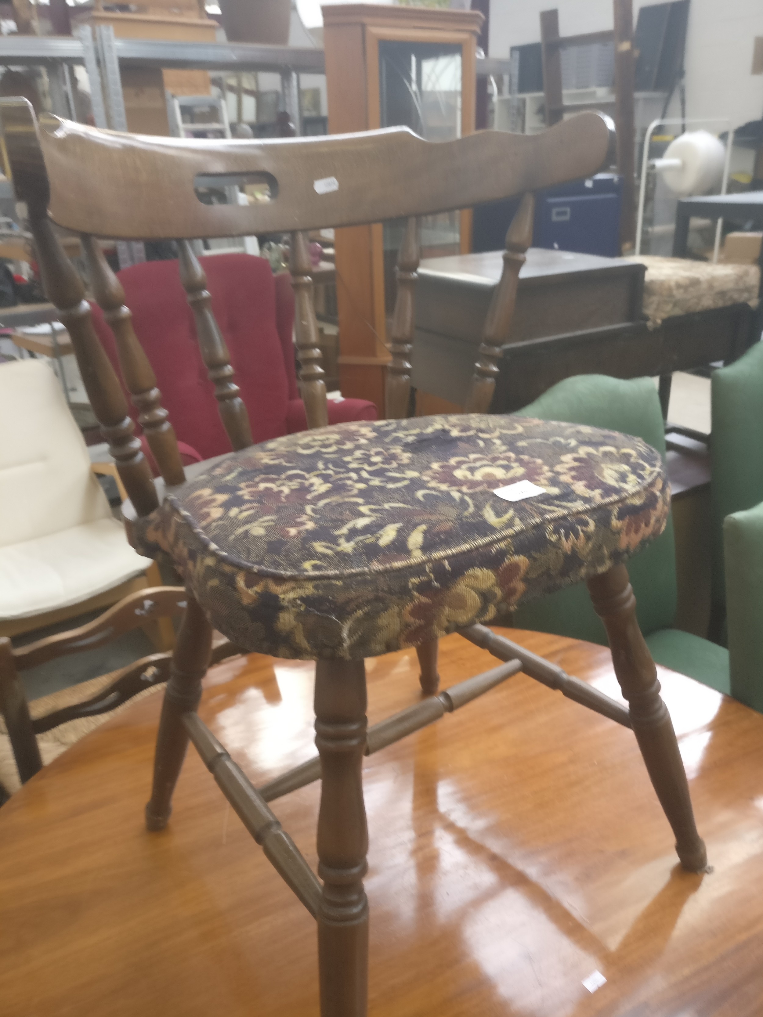 A vintage spindle backed Captain's chair with fixed seat cushion