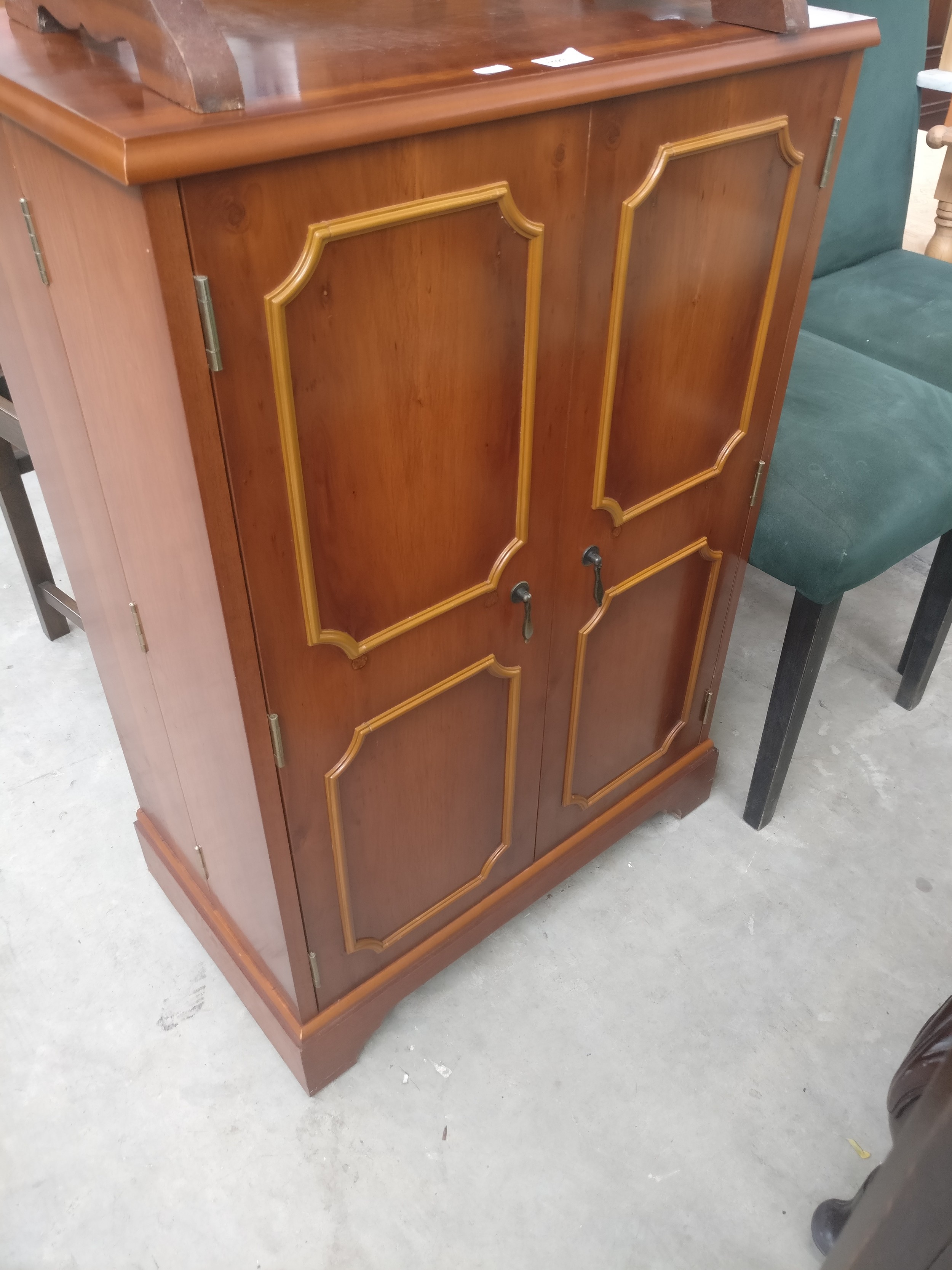 A small 2 door Yew wood storage cupboard with fold-out shelved doors