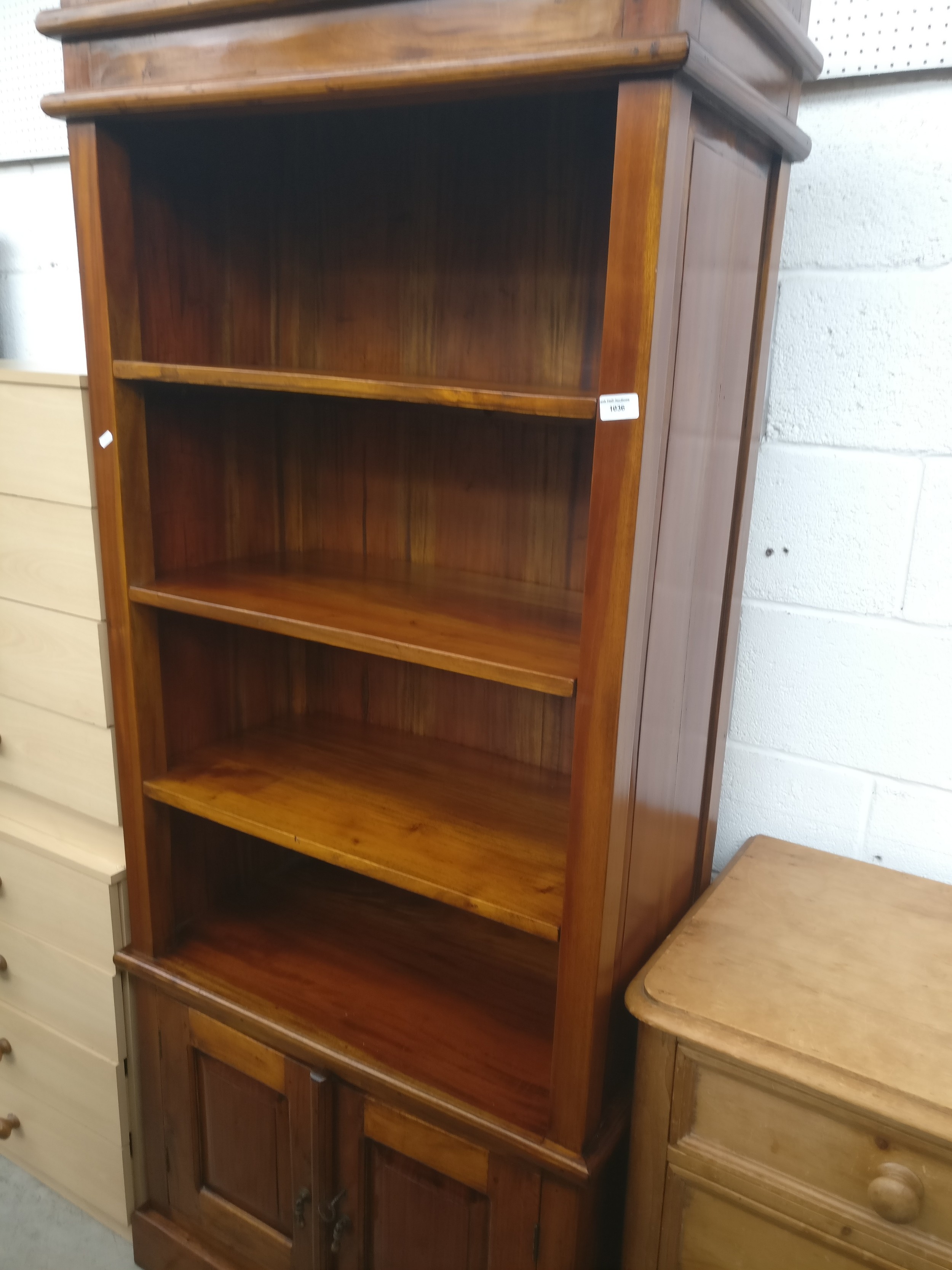 A large hardwood open shelf unit with lower double cupboard