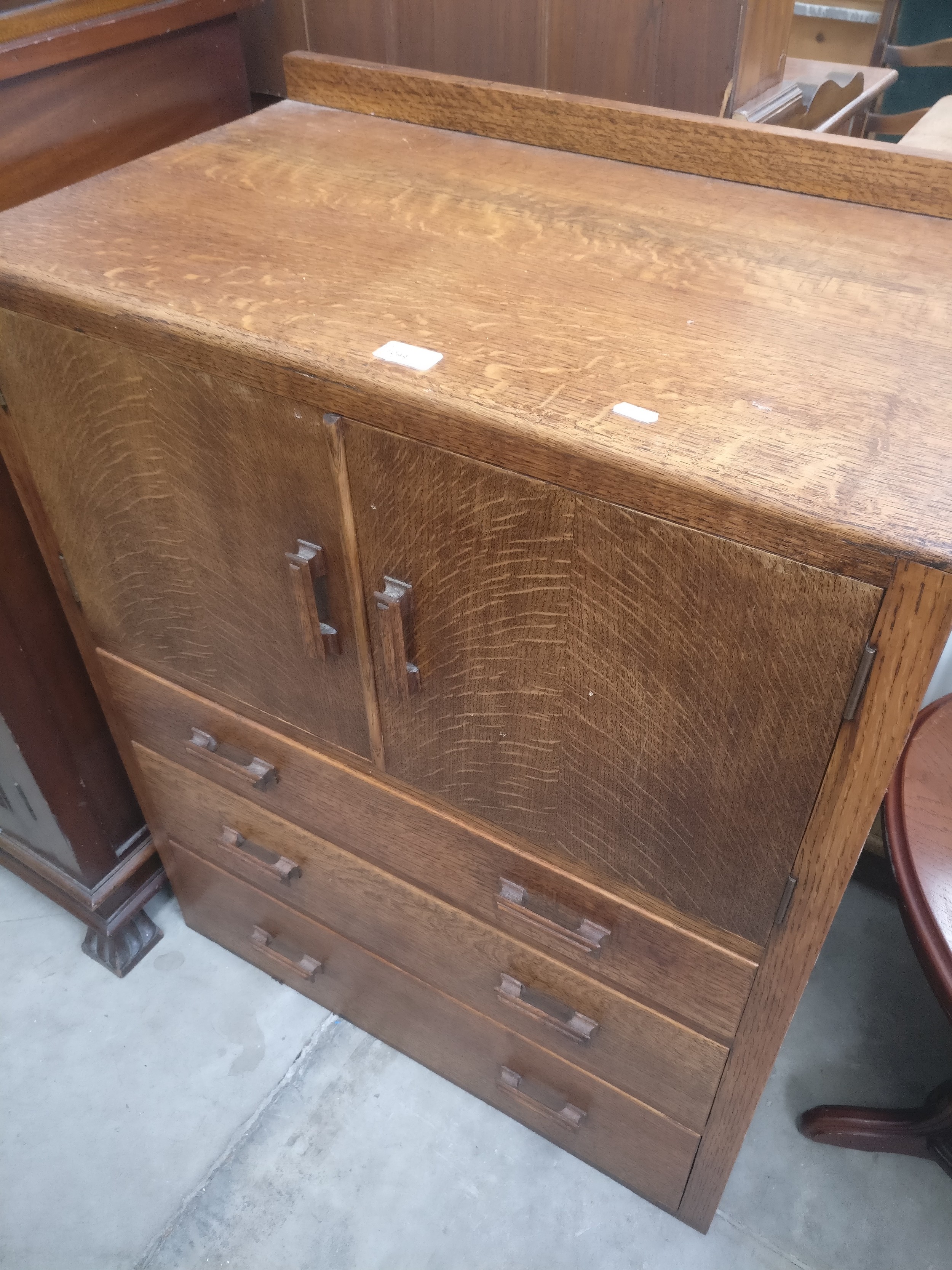 A vintage oak 3 drawer tallboy with 2 door cupboard