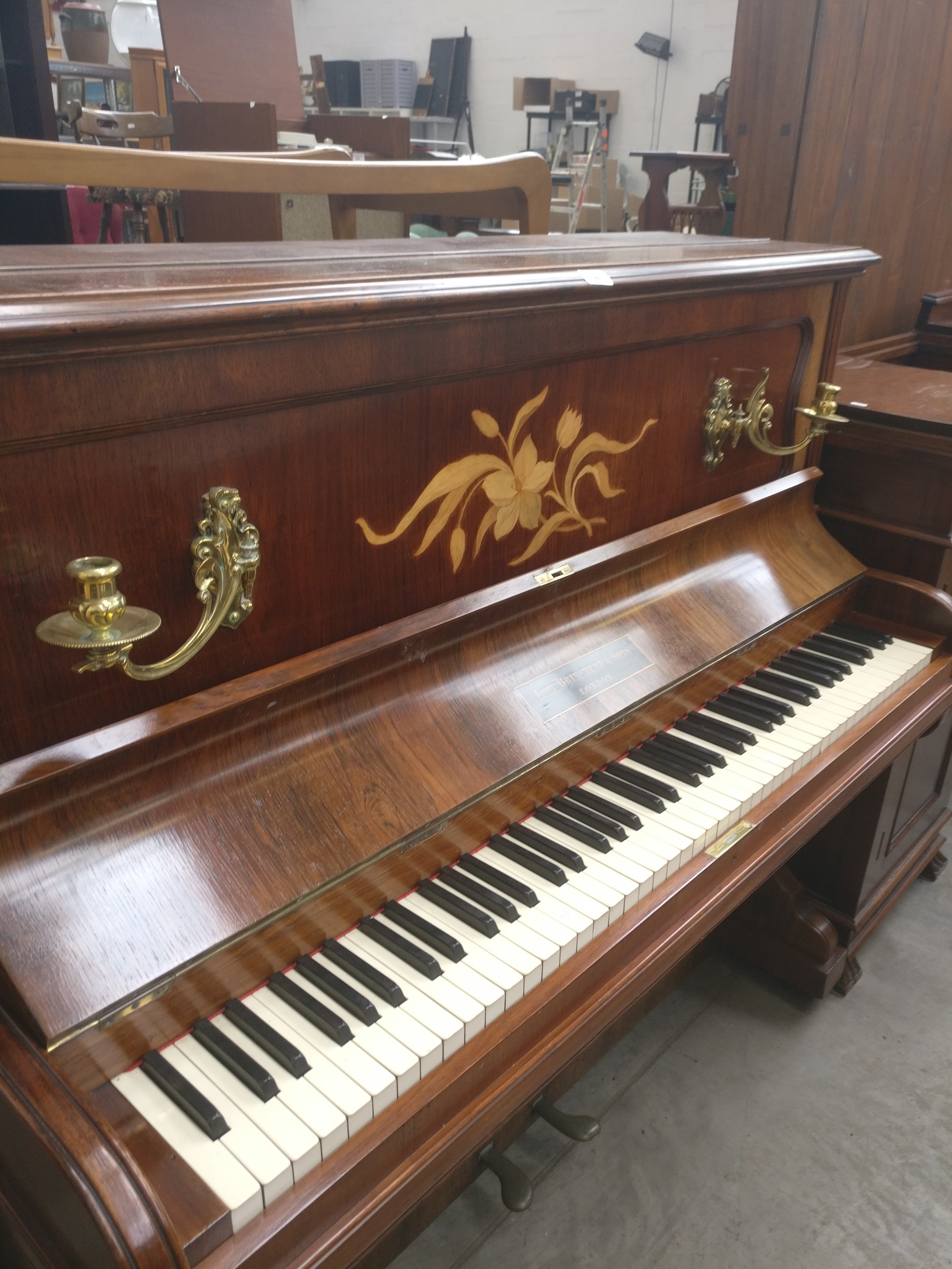 A vintage John Brinsmead & Sons upright piano with inlaid front panel and brass