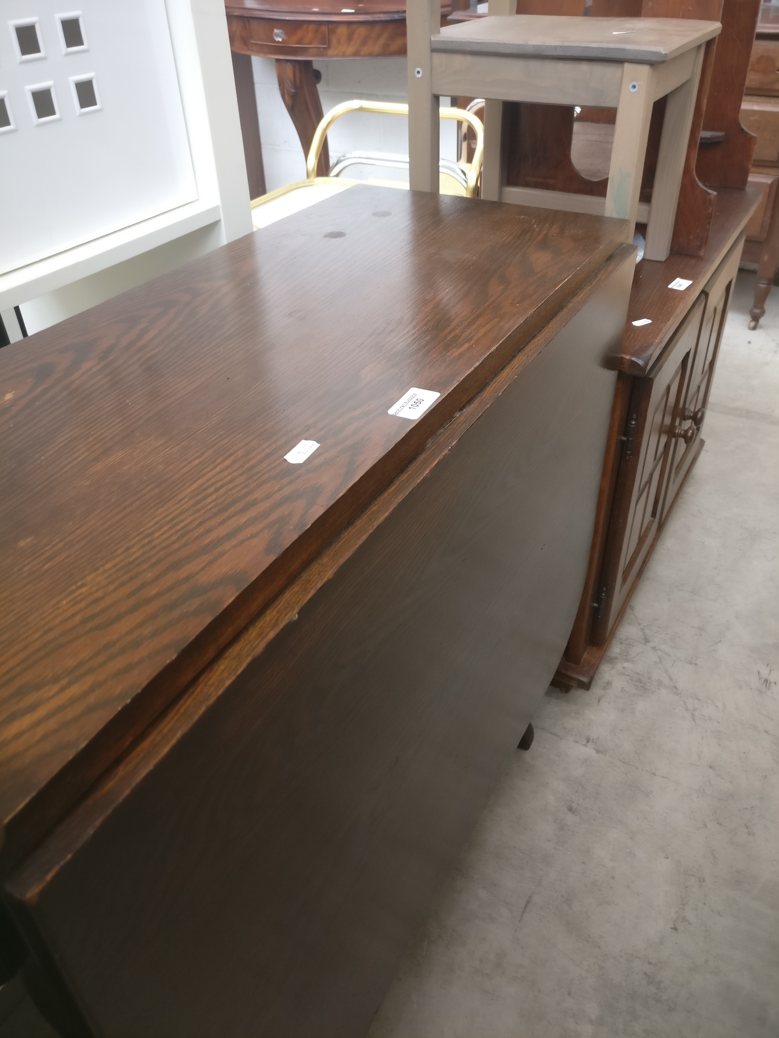 A vintage solid oak drop leaf dining table with folding base