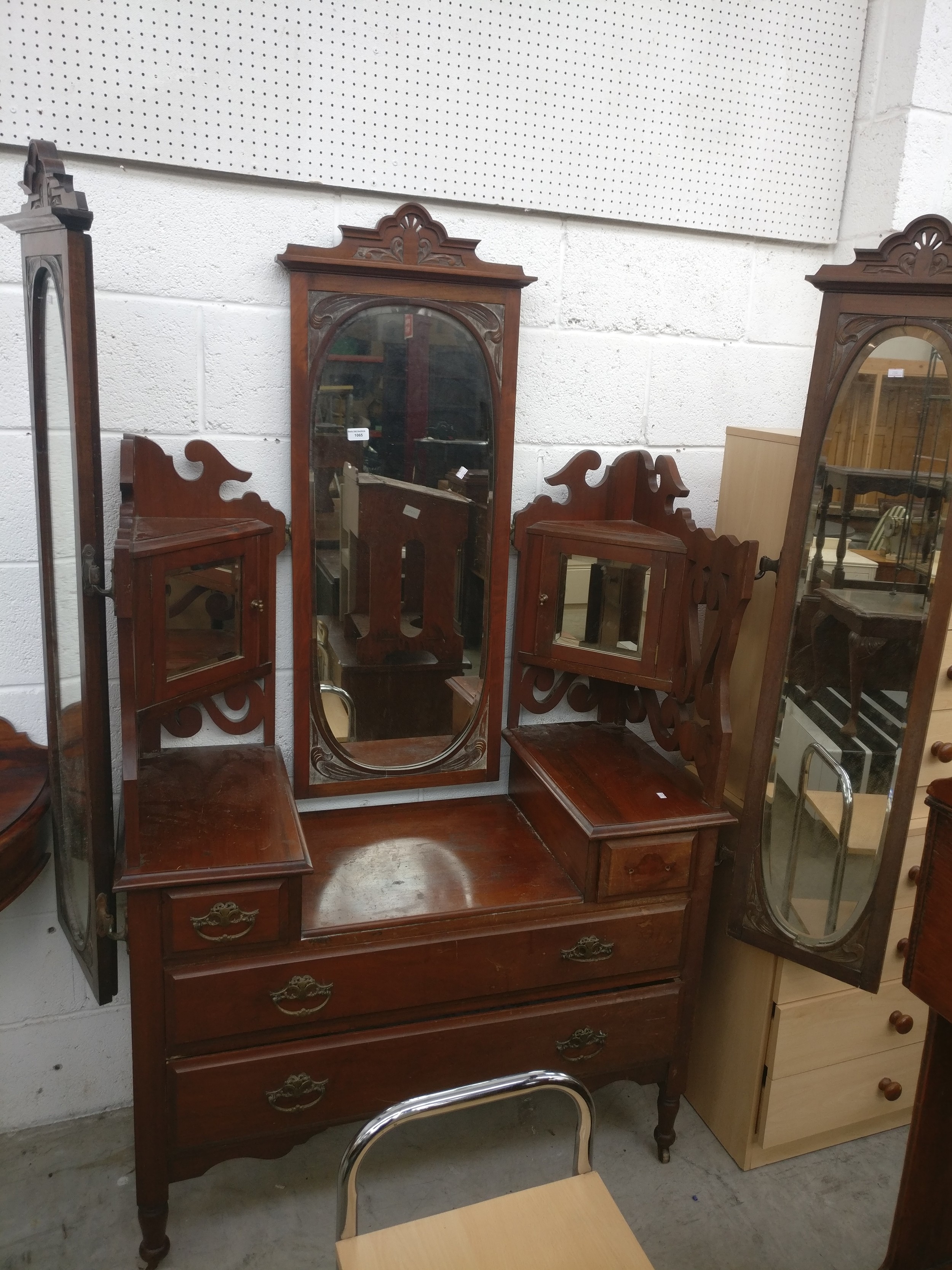 A vintage drop centre carved mahogany dressing chest with adjustable mirrors