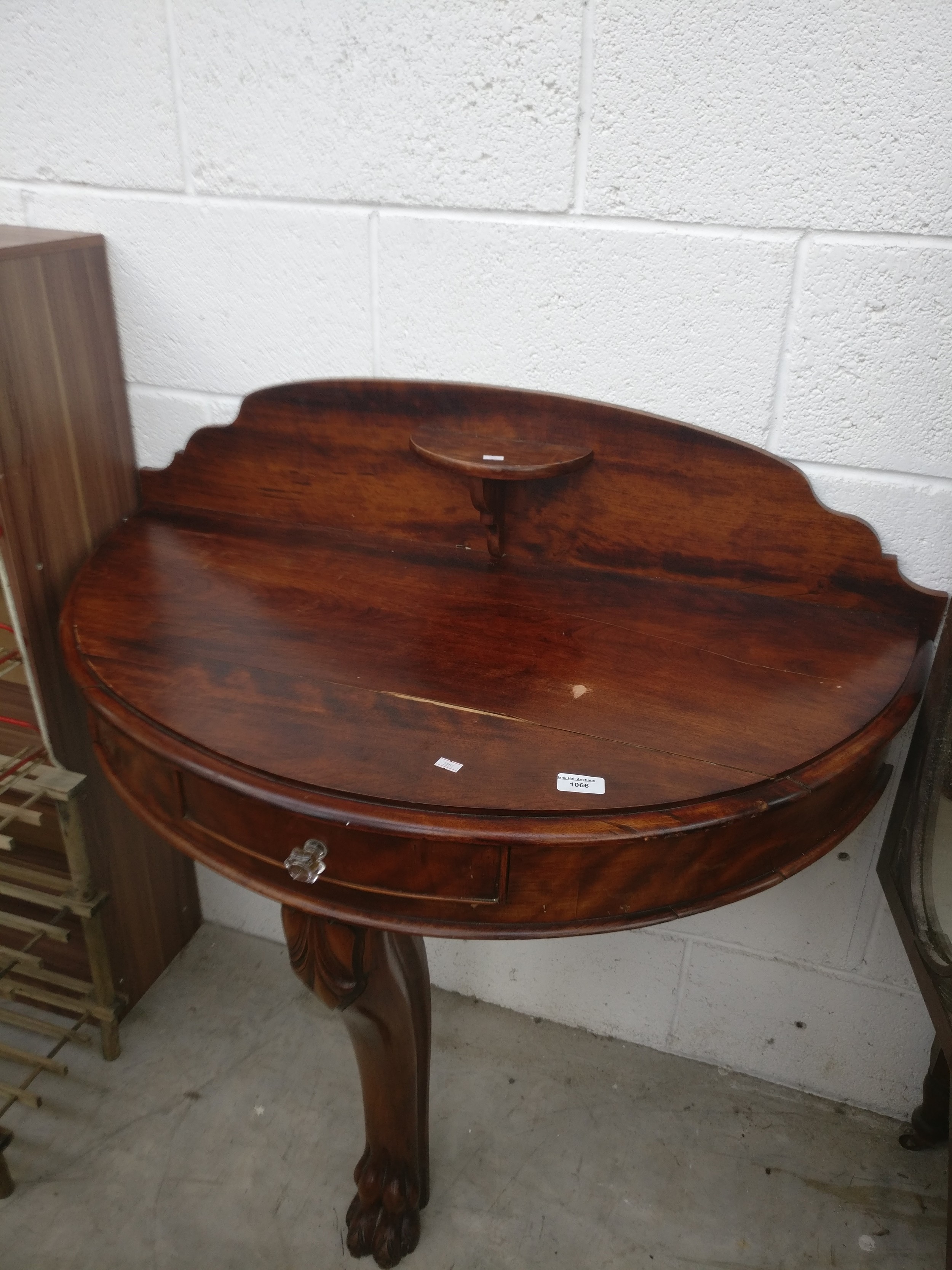 A large vintage wall mounted demi lune table with single drawer and carved claw