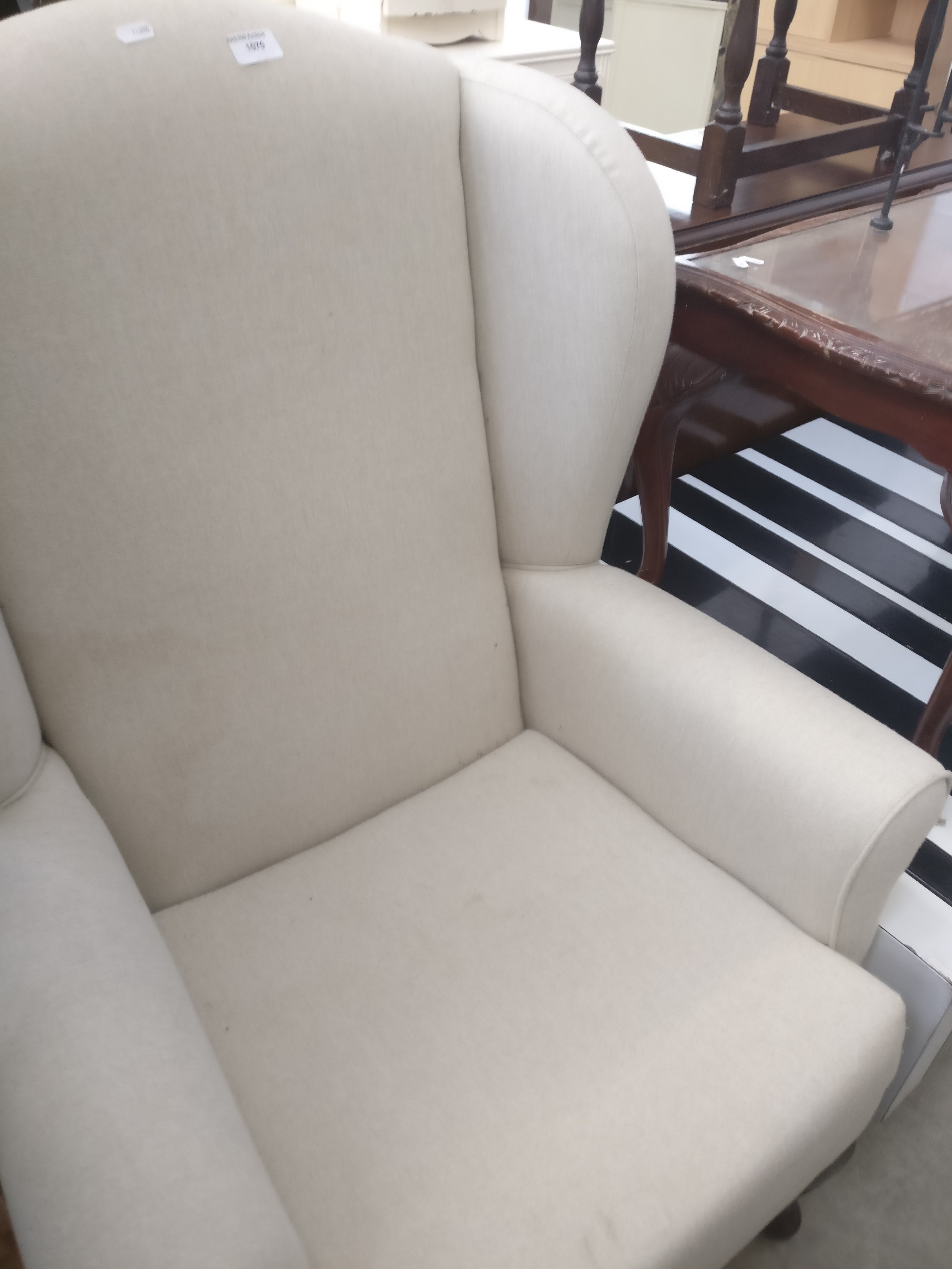 An upholstered wing back armchair on Queen Anne style legs