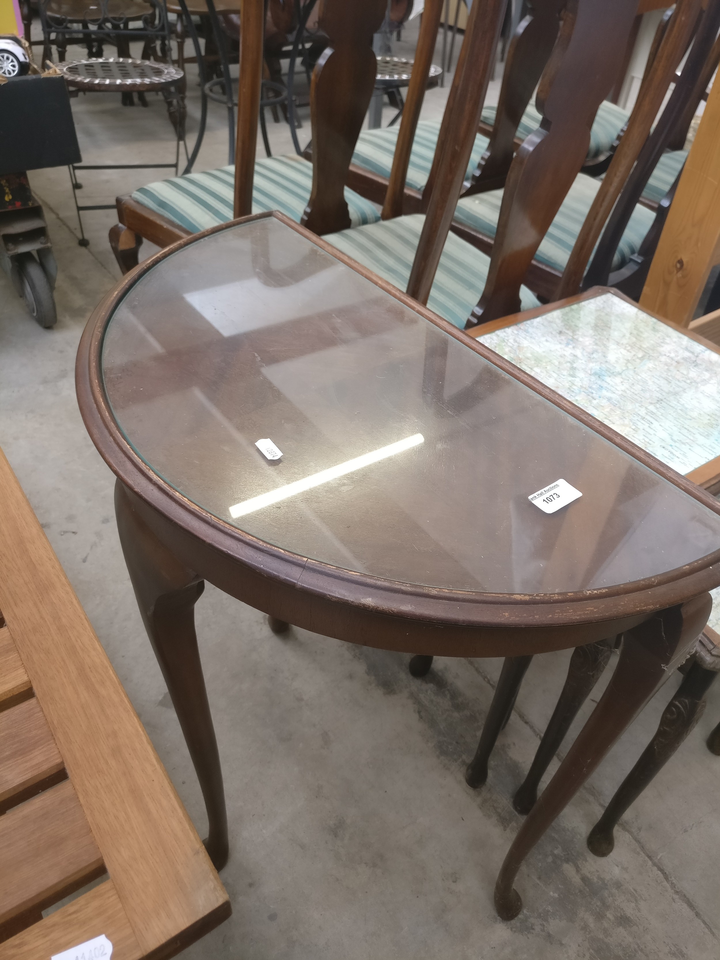 A small vintage glass topped demi lune table