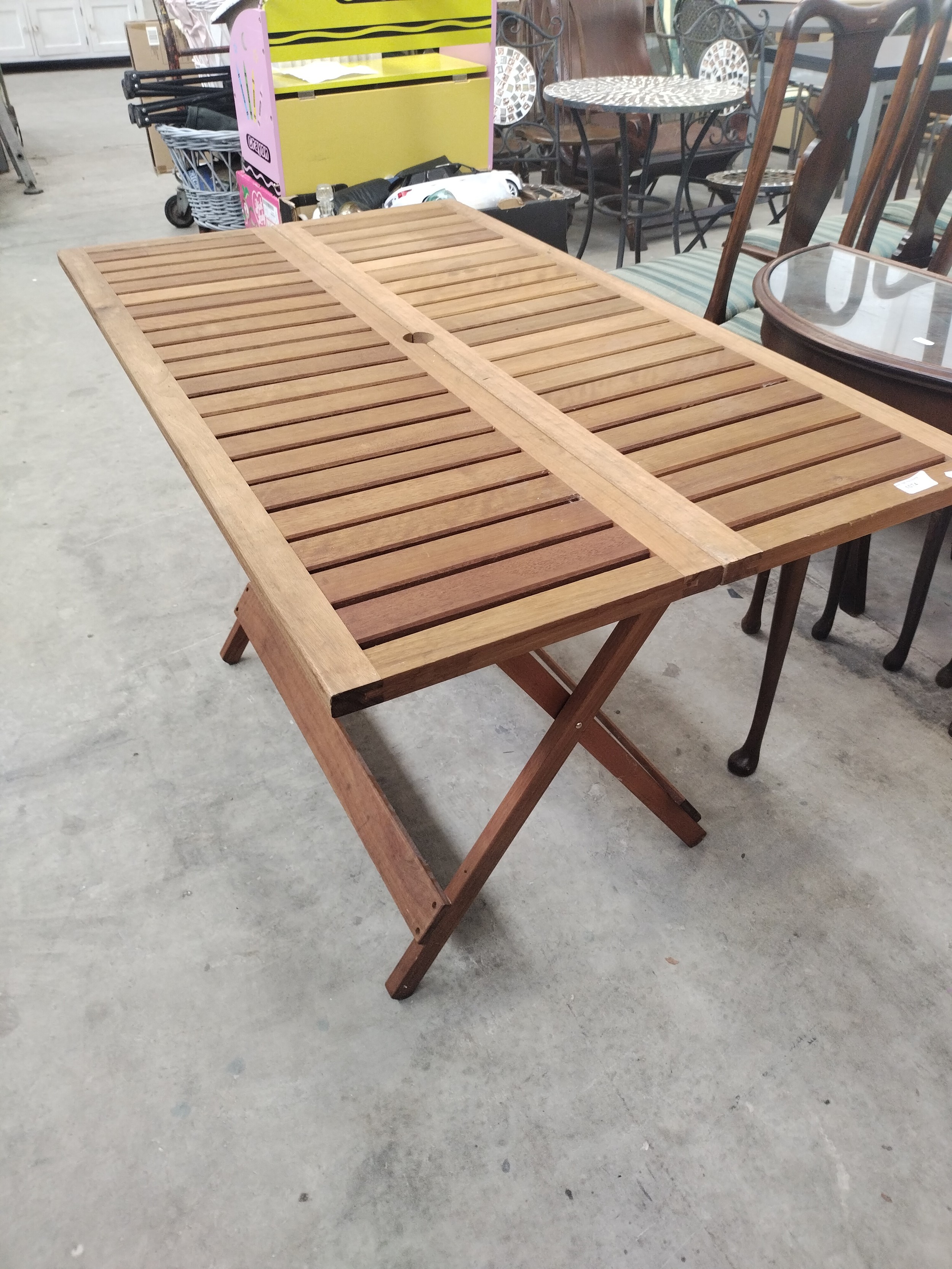 A folding wooden slatted top patio table