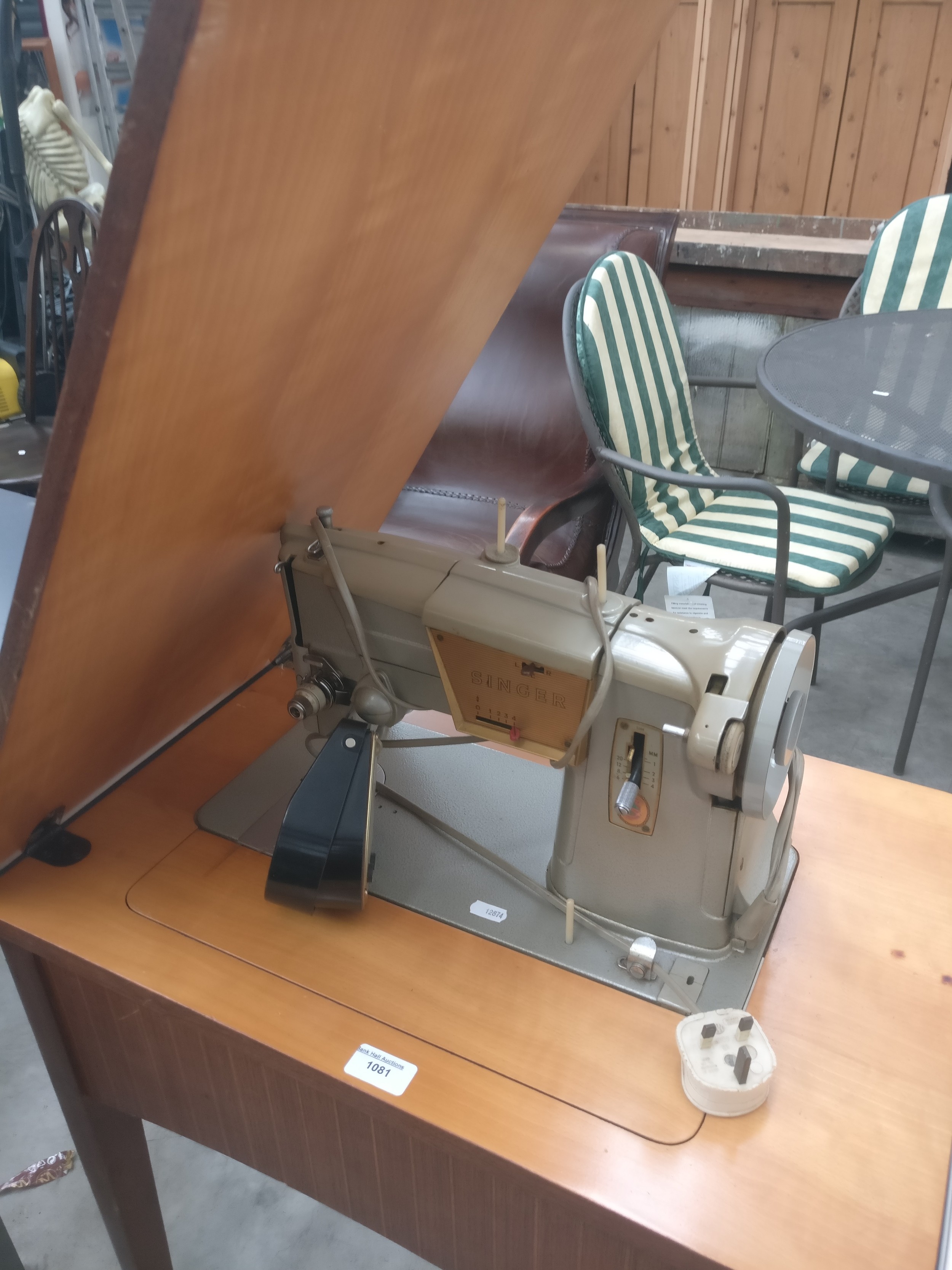 A vintage electric SINGER sewing machine in folding table stand