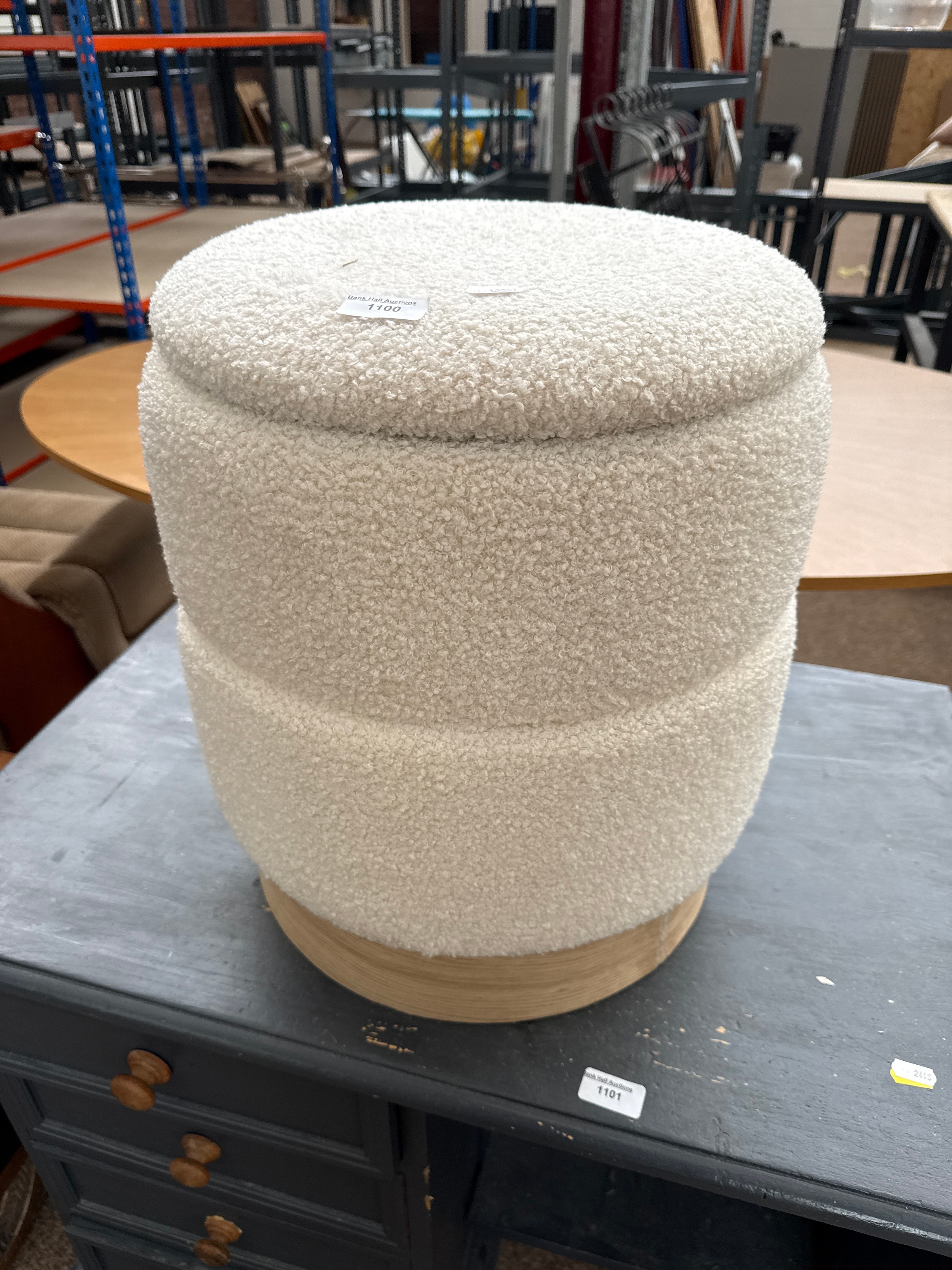 An upholstered linen box stool