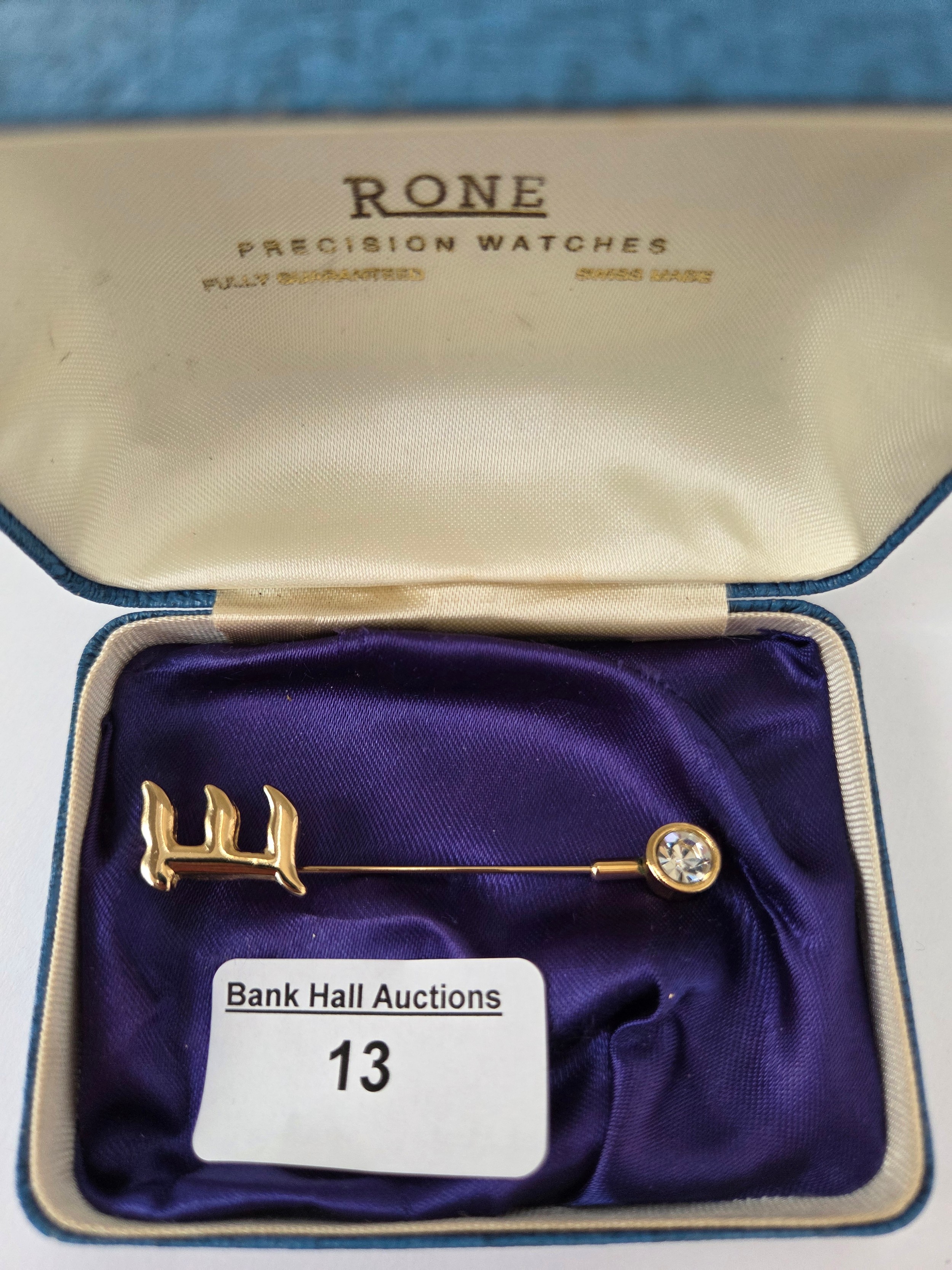 Gold coloured letter E brooch