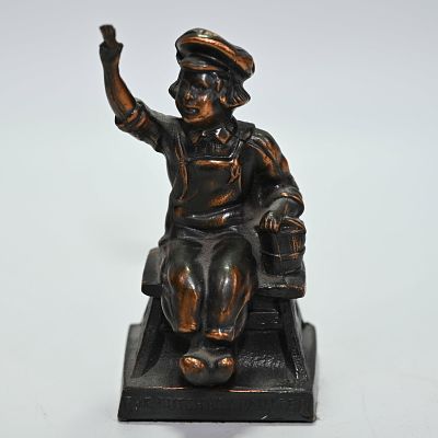 Dutch Boy Painter Figural Paperweight. A statue of the Dutch Boy painting while sitting on a 