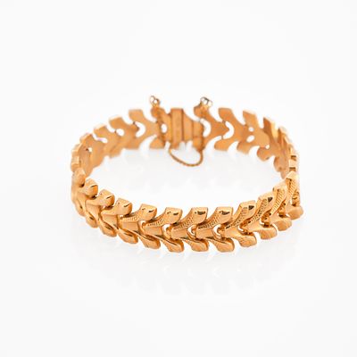Gold braceletDesigned as series of articulated chevron links in textured goldStamped 750 in a 