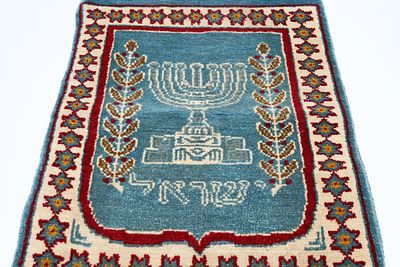 שטיח קיר יהודי 
שטיח קיר עם מנורה והכיתוב: "ישראל". סביב המנורה ענפי זית, ובפינות השטיח מגני 