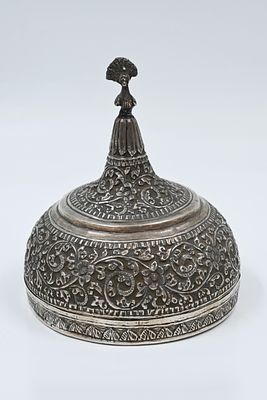 קופסא עשויה מכסף, קשמיר הודו, חתום. 
מעוטרת בעבודת יד של צמחייה ופרחים , בראש המכסה דמות 