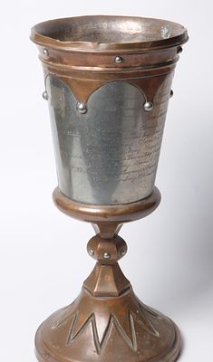 גביע ענק. עשוי נחושת ושילוב כסף - מעוטר בחריטות כיתוב בלועזית. חתום בתחתית לשנת 1908. מידות: 