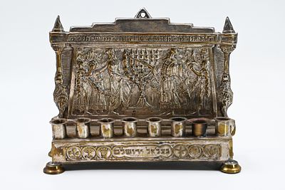 Menorah made by Bezalel. Eretz Israel, early 20th century. Hammered brass, silver-plated. 