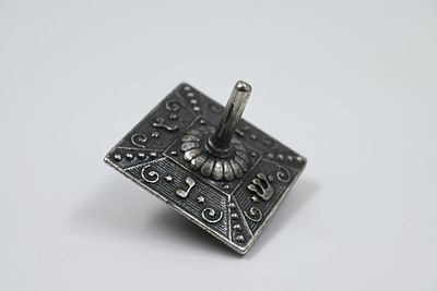 סביבון ברונזה יצוקה, חתום: ירושלם.
בחלקו העליון מובלט הכיתוב "נס גדול היה שם". גובה: 5 ס' 