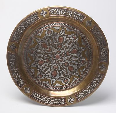 Islam . Plate made of Damascus brass. 19th century, decorated with damask work with an Arabic 