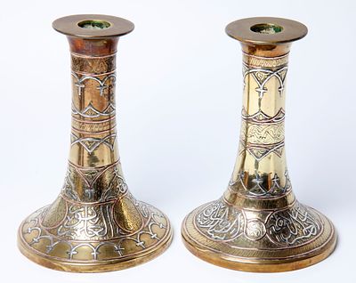 A pair of candlesticks made of brass with damask work decorated with damask work with silver 