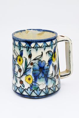 ספל בעל ידית, מעוטר בצמחים ובציפורים. תוצרת סדנת קרקשיאן-בליאן. חמר צבוע ומזוגג. חתום: 