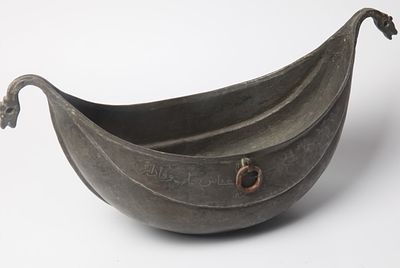 קשקול בצורת סירה, שנת 1865, בסיס אובלי בולט ודפנות מוארכות עד לידיות עם קווים גאומטרים ישרים. 