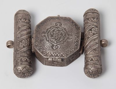 בית קמע איסלמי , עשוי כסף, מעוטר בשני עומדים מכסף ובניהם קופסא משושה מעוטרת בעבודת פרחייה 