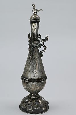 A hexagonal flask, standing on a dome-shaped foot and decorated with floral patterns. Three 