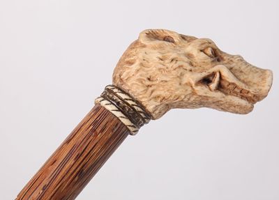 A walking stick with a handle. 
A wooden walking stick with a handle, handmade by an artisan. 