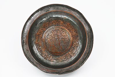 קערת נחושת פרסית מהתקופה הקאג'ארית (Qajar), המאה ה-19. 
במרכז הקערה מופיע עיטור צפוף המשלב 