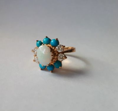 טבעת מעצבים זהב 14K 
משובצת באבן אופל מרכזית, בהיקף אבני טורקיז ו-52 נקודות יהלומים 
משקל: 