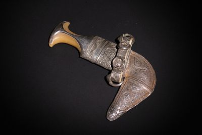 A Yemeni Silver and Horn Jambiya Dagger with Ornate Sheath. A curved Yemeni jambiya dagger 