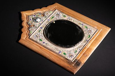 A Qajar Silver and Enamel Wall Mirror. This Qajar mirror is set within a wooden frame 