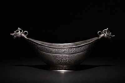 An Islamic Safavid Copper Kashkul Beggar's Bowl with Dragon Head Terminals. A copper Kashkul 