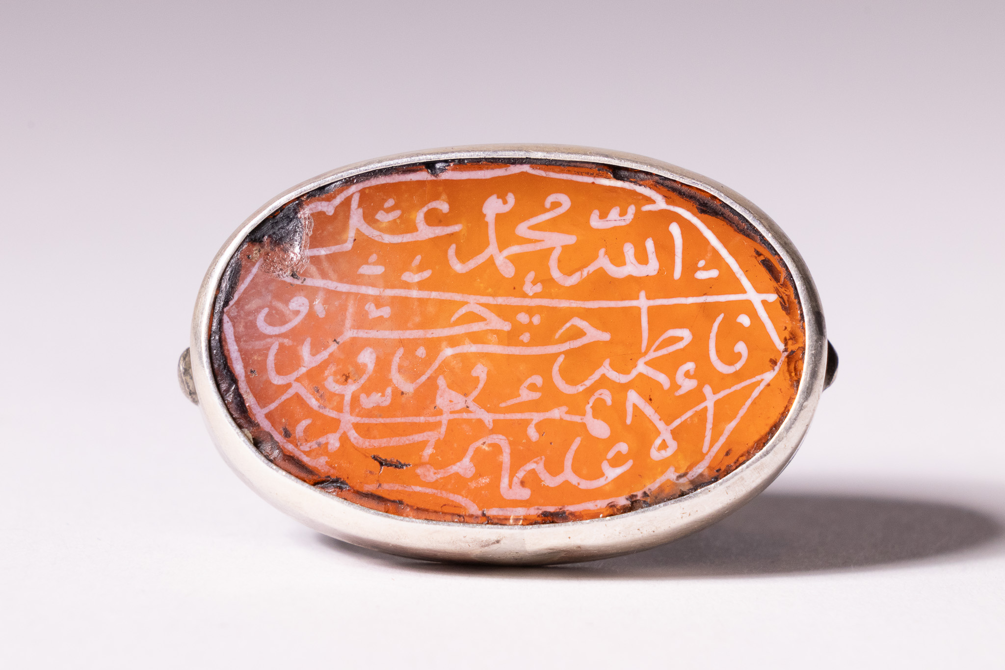 AN ISLAMIC SILVER ENGRAVED CARNELIAN TALISMANIC RING.