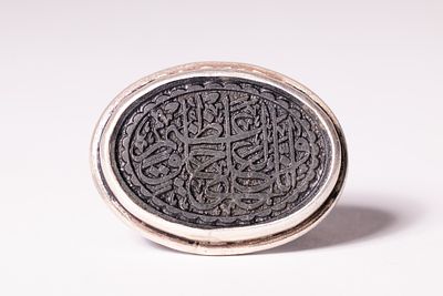 AN ISLAMIC SILVER AND INLAID STONE SIGNET SEAL RING. This signet or seal ring features a silver 