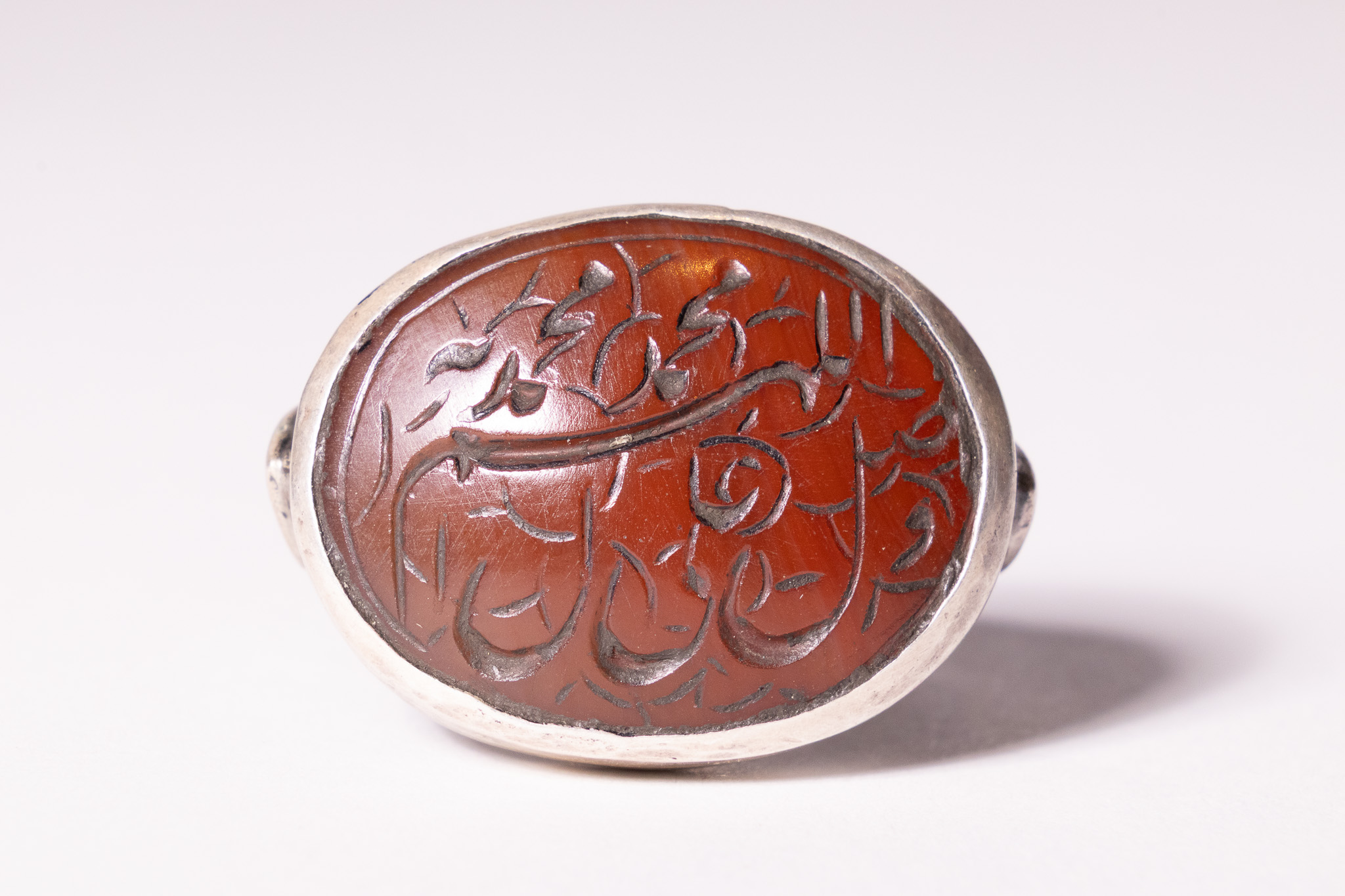 AN ISLAMIC SILVER AND INTAGLIO CARNELIAN SEAL RING.