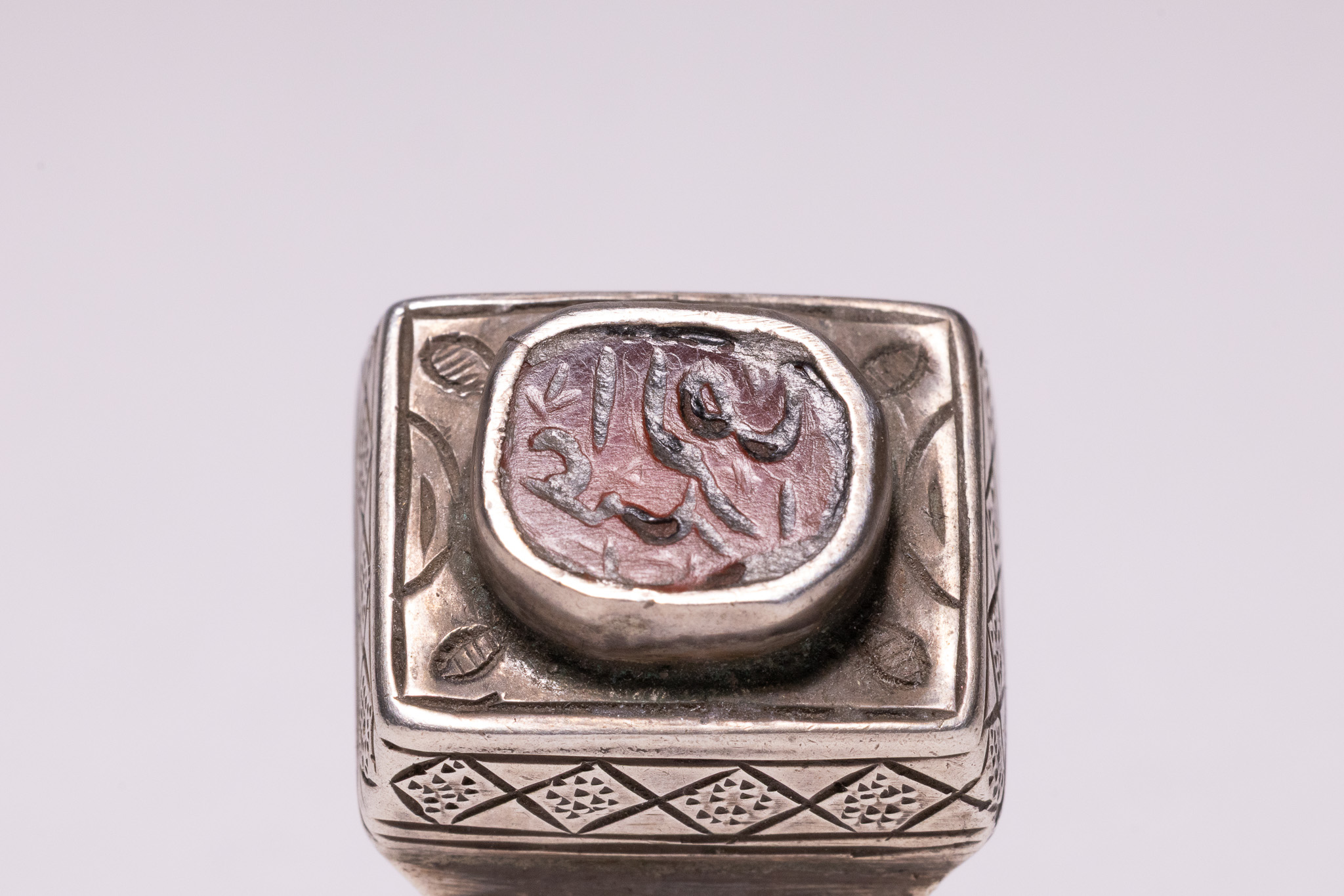 AN ISLAMIC MIDDLE EASTERN SILVER AND CALLIGRAPHIC CARNELIAN INTAGLIO SIGNET RING.