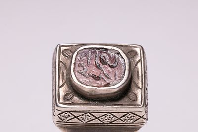 AN ISLAMIC MIDDLE EASTERN SILVER AND CALLIGRAPHIC CARNELIAN INTAGLIO SIGNET RING. A substantial 