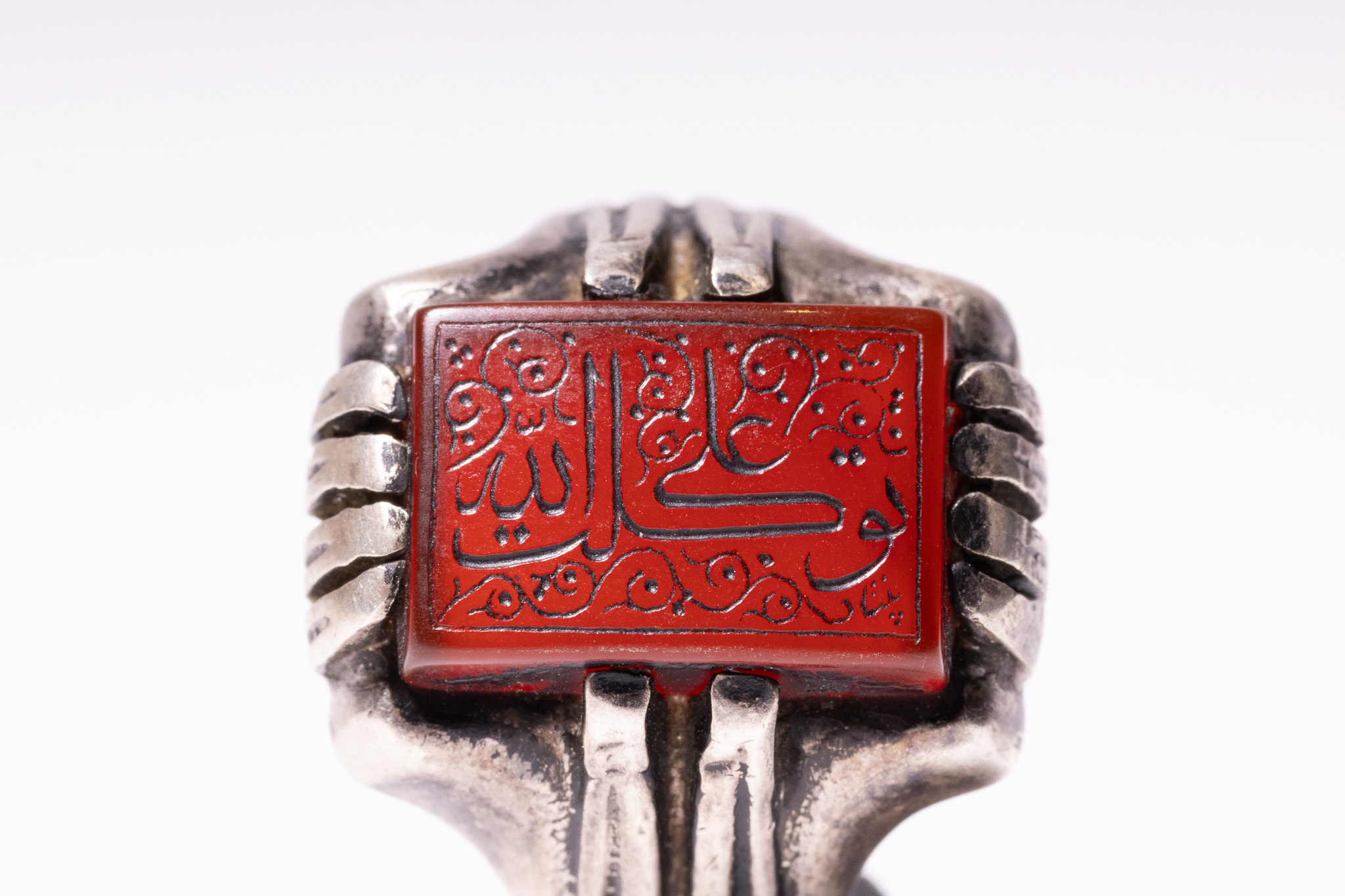 AN ISLAMIC SILVER AND INSCRIBED CARNELIAN SIGNET RING.