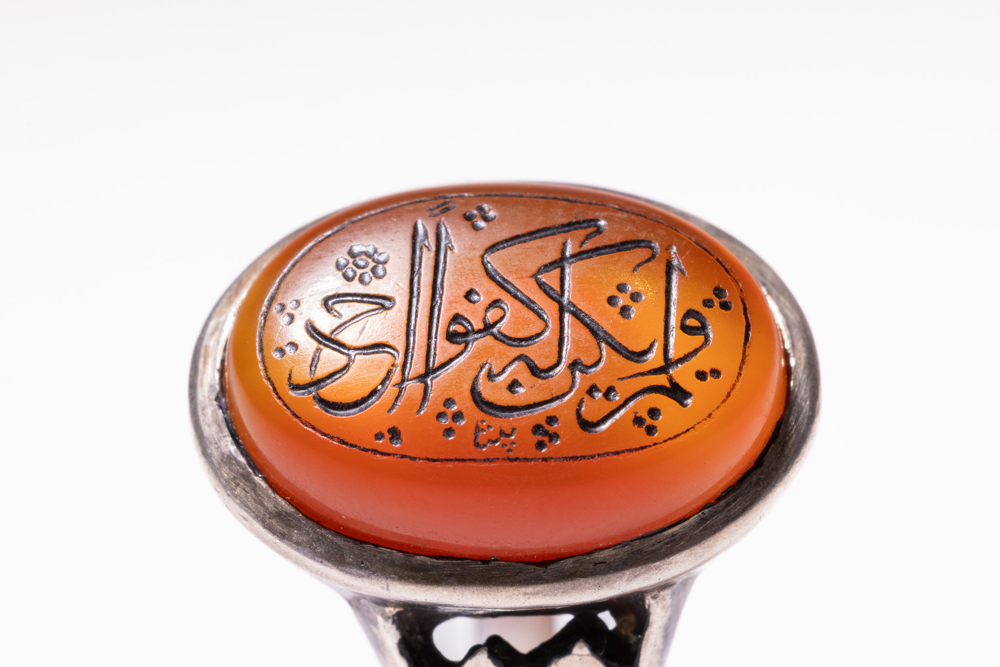 AN ISLAMIC ENGRAVED CARNELIAN AND SILVER SIGNET RING.