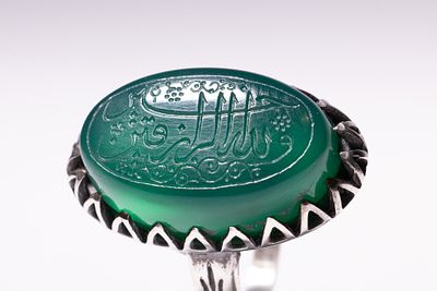 AN ISLAMIC SILVER TALISMANIC SIGNET RING WITH INTAGLIO-ENGRAVED GREEN AGATE. A talismanic 