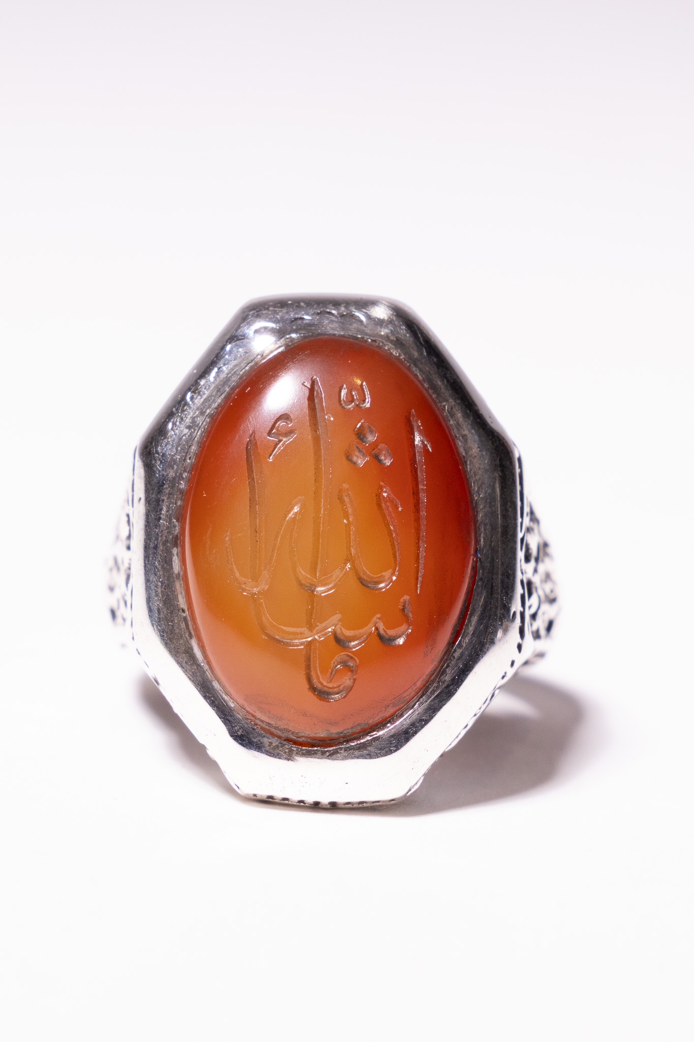 AN ISLAMIC SILVER SIGNET RING WITH AN ENGRAVED CARNELIAN AGATE CABOCHON.
