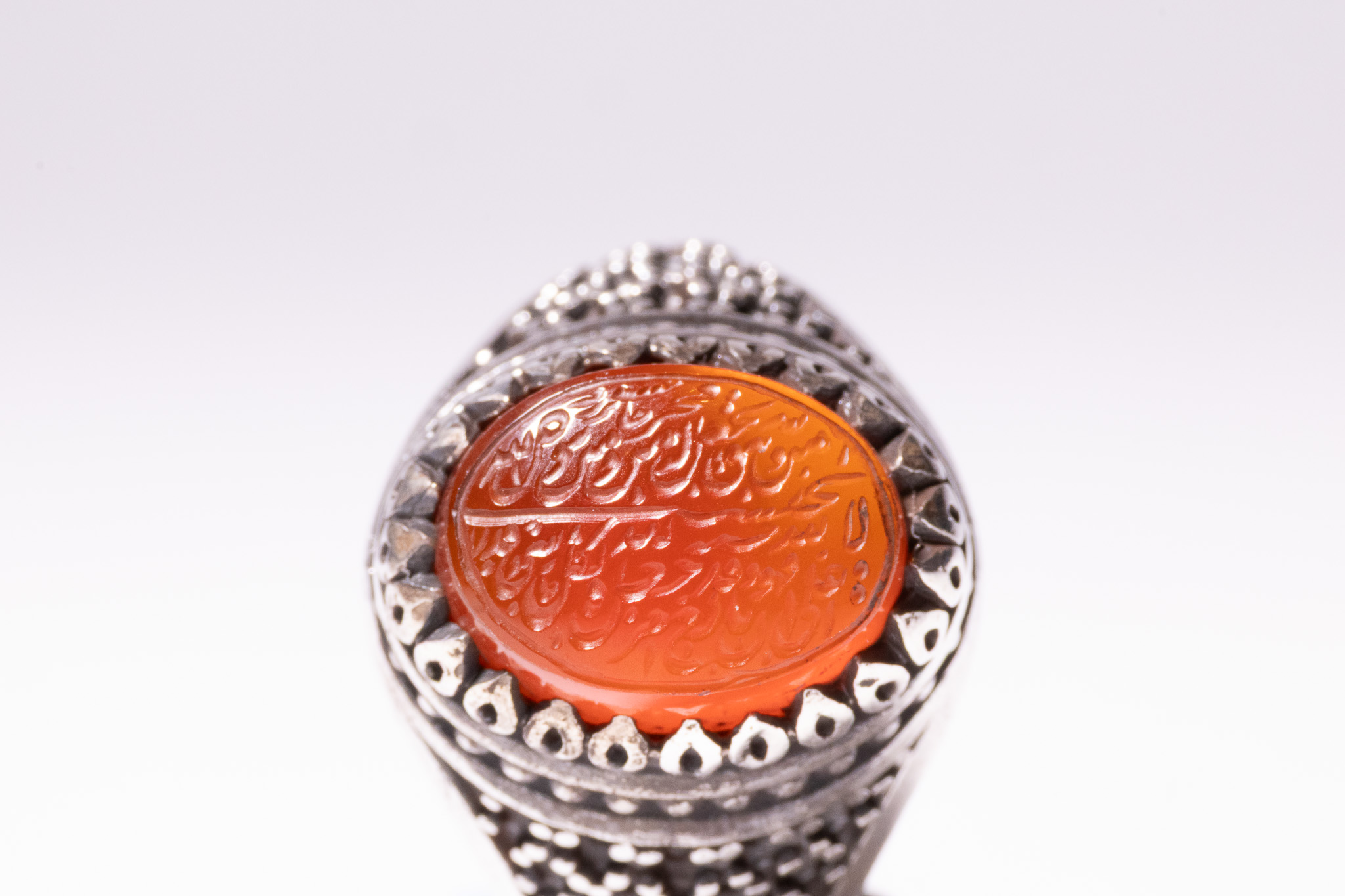 AN ISLAMIC SILVER AND INTAGLIO-CARVED CARNELIAN SIGNET RING WITH MAKER'S MARK FOR SHA'BAN.