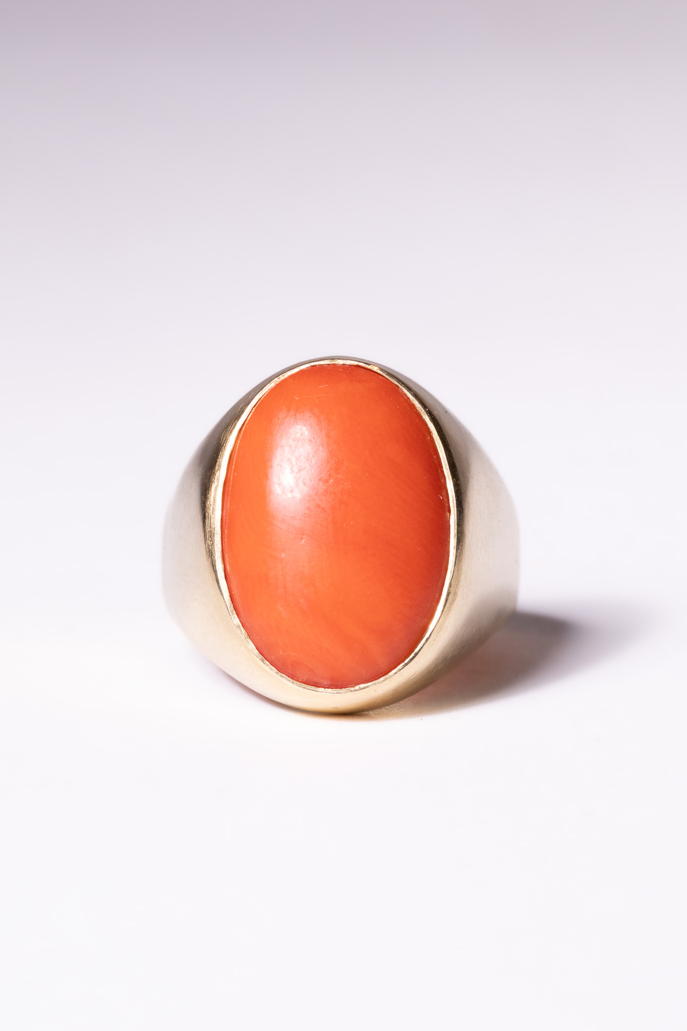 A 18 CARAT YELLOW GOLD AND OVAL CABOCHON CORAL SIGNET-STYLE RING.
