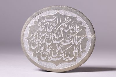 AN ISLAMIC CARVED HEMITITE CALLIGRAPHIC ROUNDEL WITH QURANIC INSCRIPTIONS. A calligraphic 