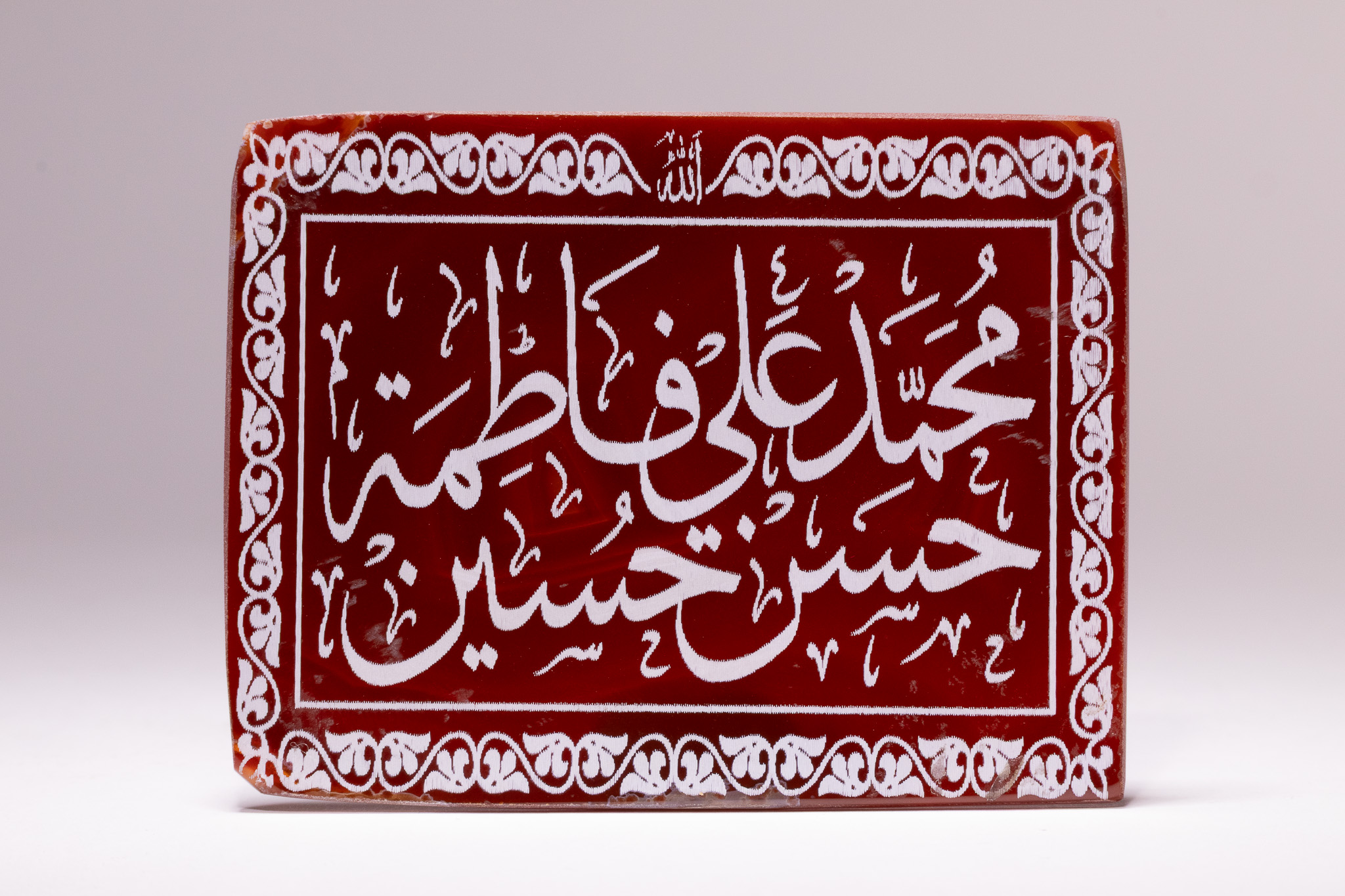 A LARGE ISLAMIC RECTANGULAR INSCRIBED RED CARNELIAN CALLIGRAPHIC PLAQUE OF THE AHL AL-BAYT.