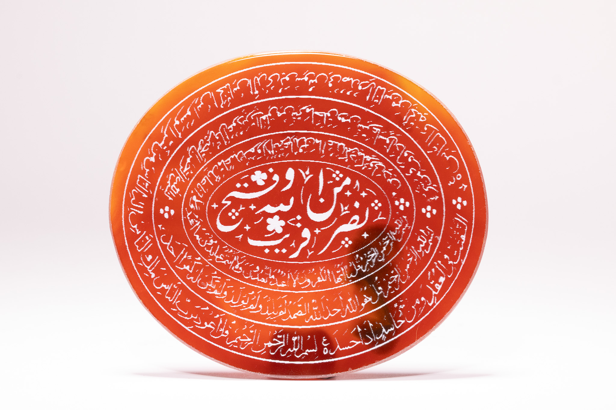 AN ISLAMIC CARNELIAN AGATE TALISMANIC PLAQUE WITH QURANIC CALLIGRAPHY.