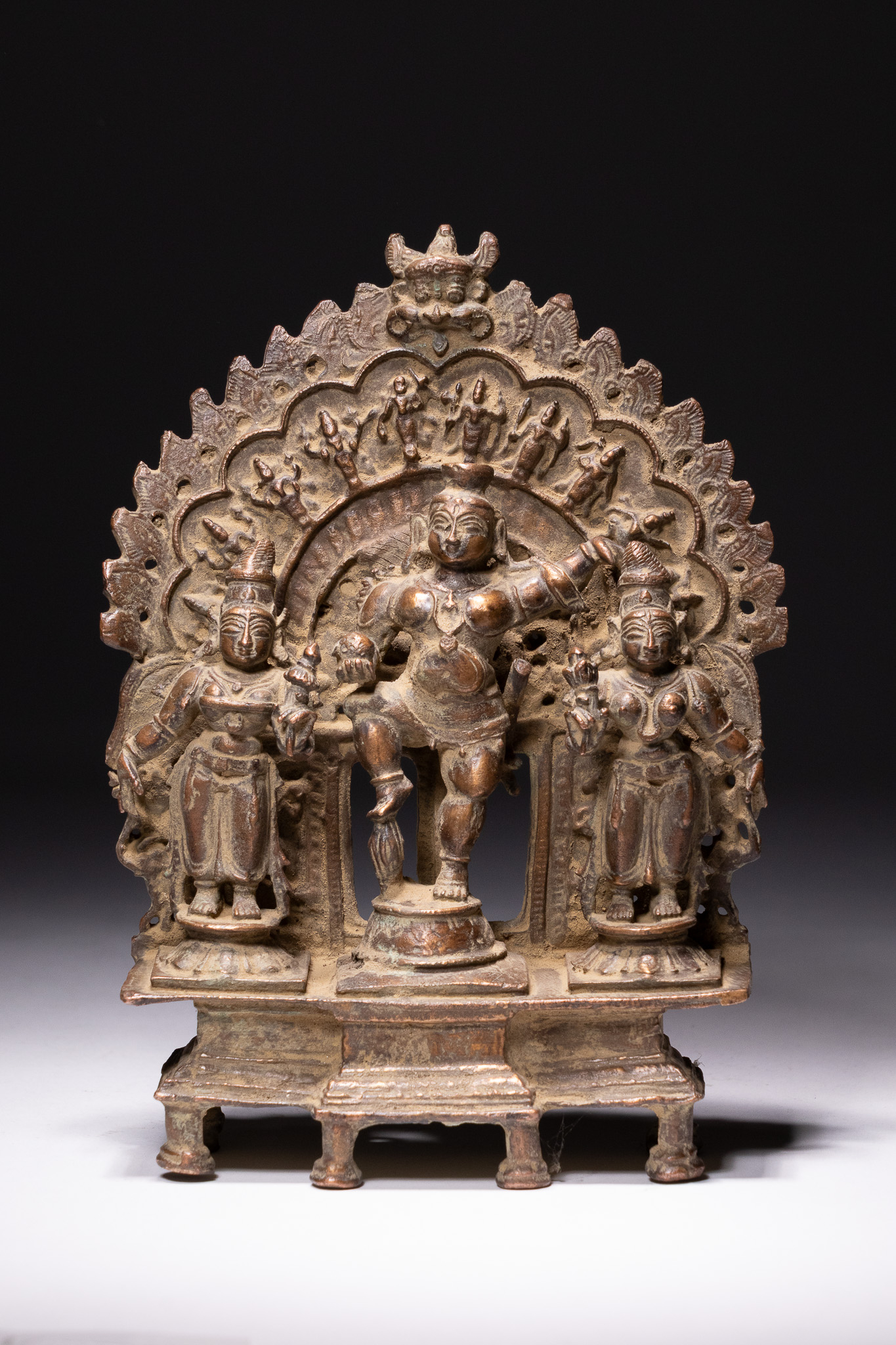AN SOUTH INDIAN BRONZE SHRINE OF NAVANEETHA KRISHNA WITH CONSORTS, 19TH-20TH CENTURY.