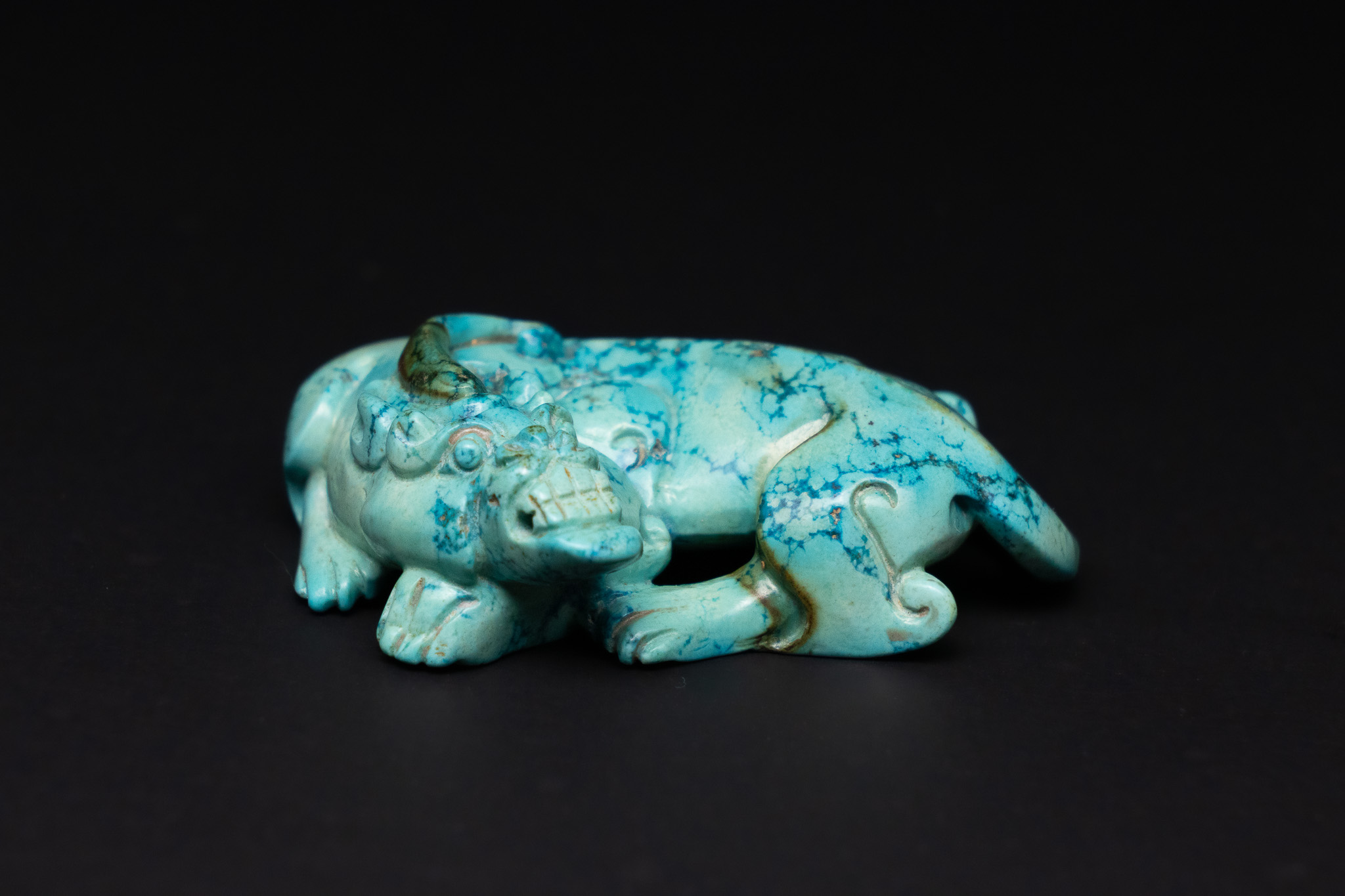 A CHINESE CARVED TURQUOISE RECUMBENT MYTHICAL BEAST.