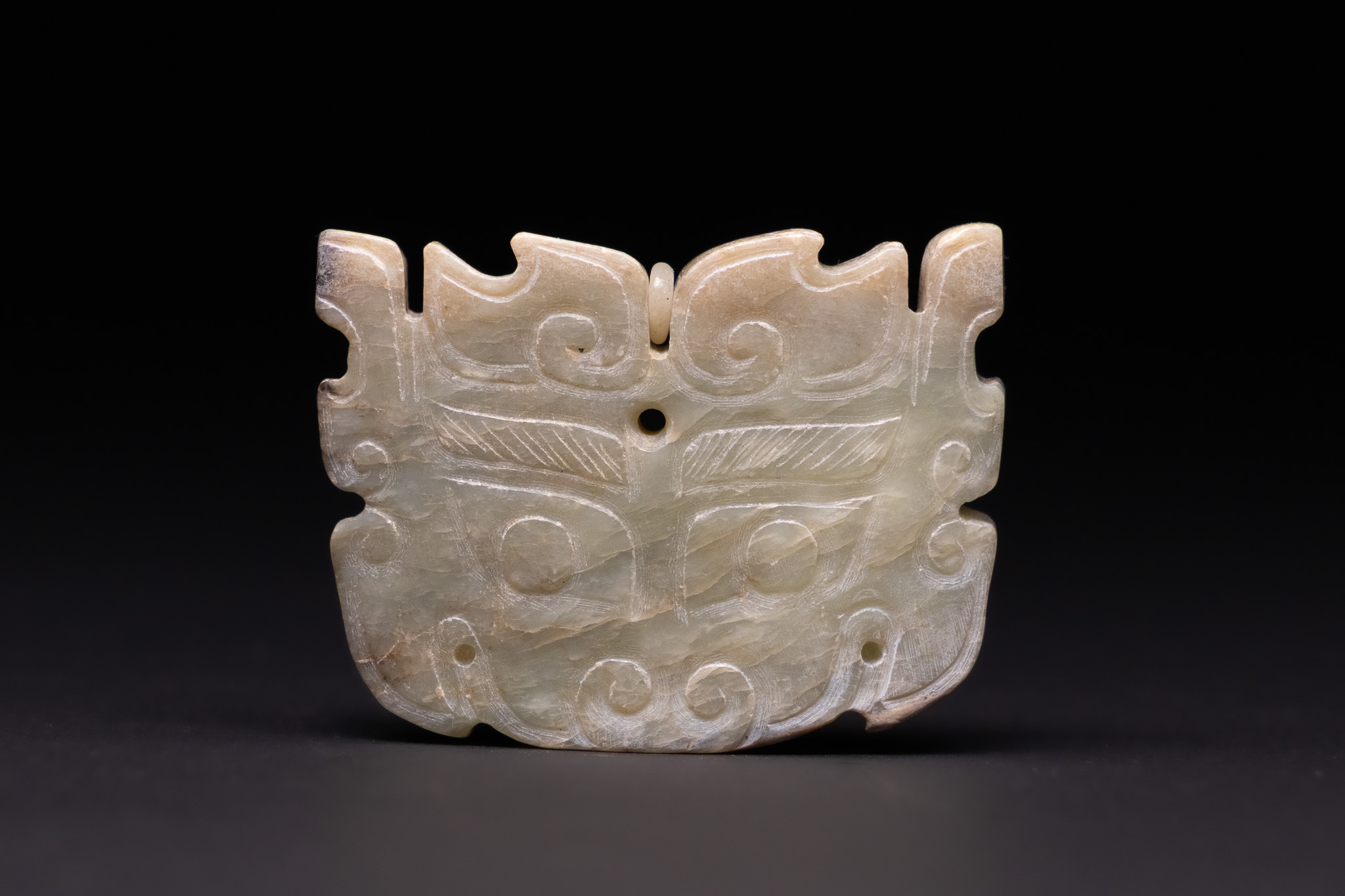 A CHINESE ARCHAISTIC CARVED JADE TAOTIE MASK PENDANT, 18TH/19TH CENTURY.